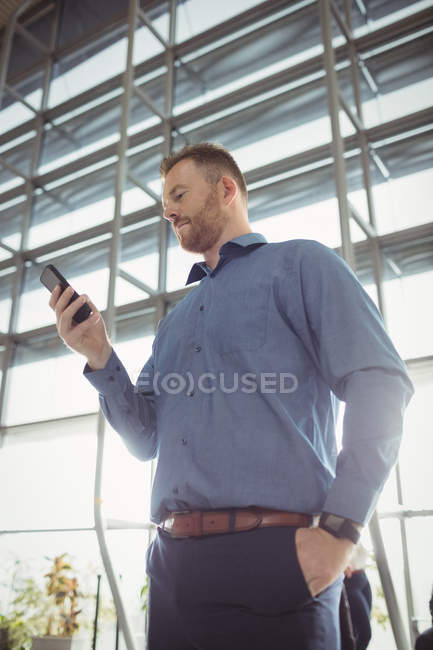 Man using mobile phone in waiting area at airport terminal — Stock Photo