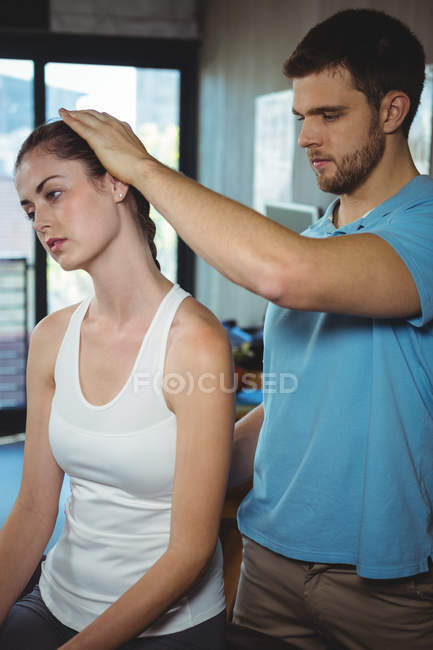 Fisioterapeuta alongamento pescoço de paciente do sexo feminino na clínica — Fotografia de Stock