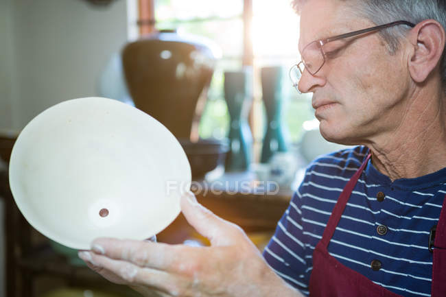 Close-up of male potter checking pot in workshop — Stock Photo