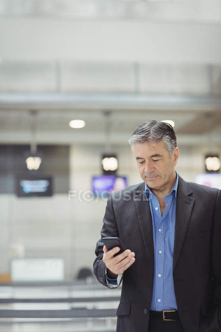 Geschäftsmann benutzt Handy im Flughafen-Terminal — Stockfoto