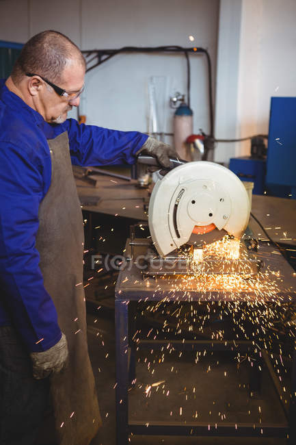 Bellissimo saldatore taglio metallo con utensile elettrico in officina — Foto stock