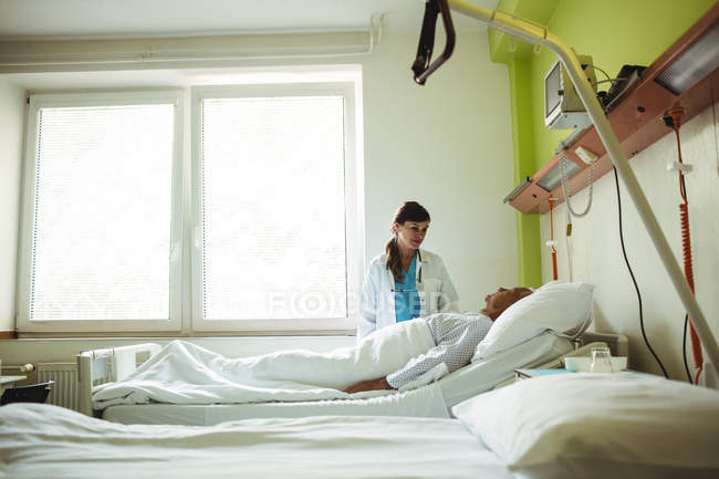 Médica examinando homem idoso no hospital — Fotografia de Stock