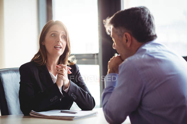 Businesswoman into discussion with colleague in office — Stock Photo
