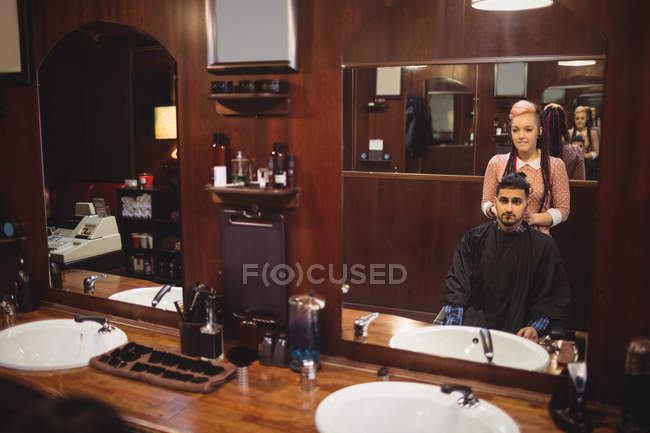 Barbeiro feminino styling cabelo do cliente na barbearia — Fotografia de Stock