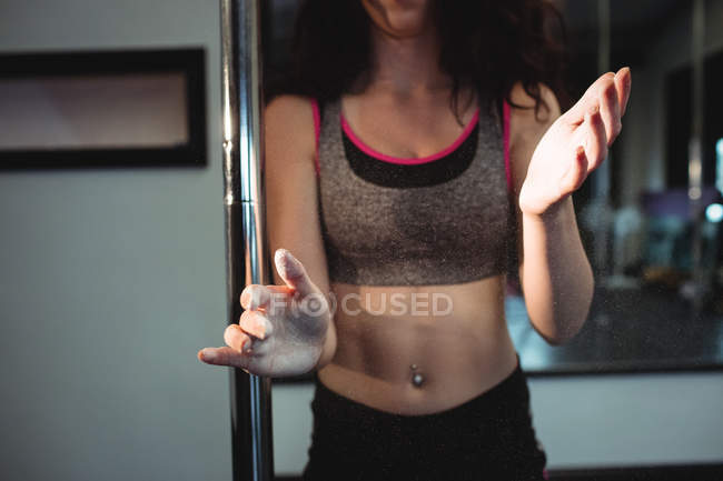 Midsection of pole dancer with powder on hands in fitness studio — Stock Photo