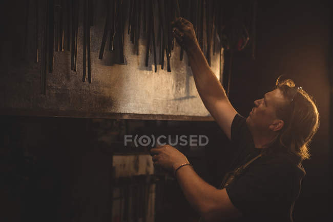 Blacksmith working at work shop — Stock Photo