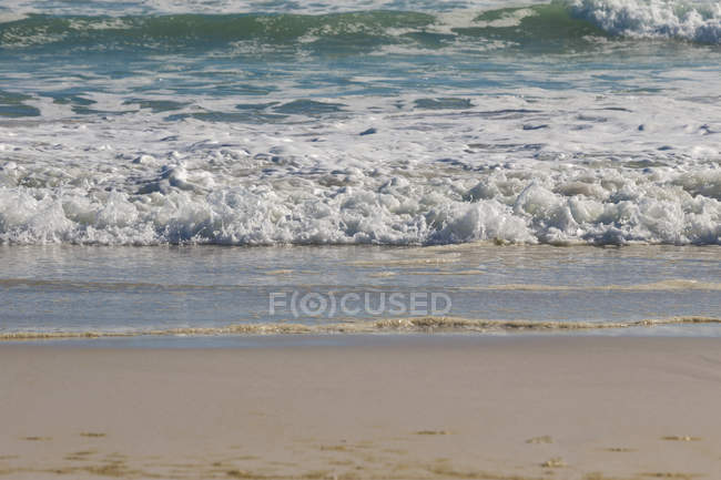 Waves crashing on the beach on a sunny day — Stock Photo