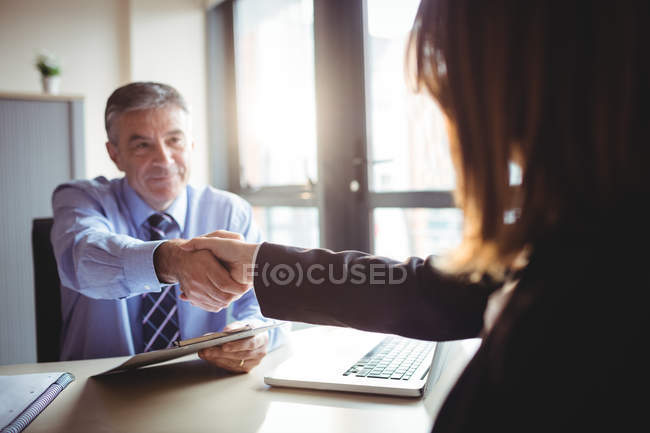Empresário apertando as mãos com colega no escritório — Fotografia de Stock