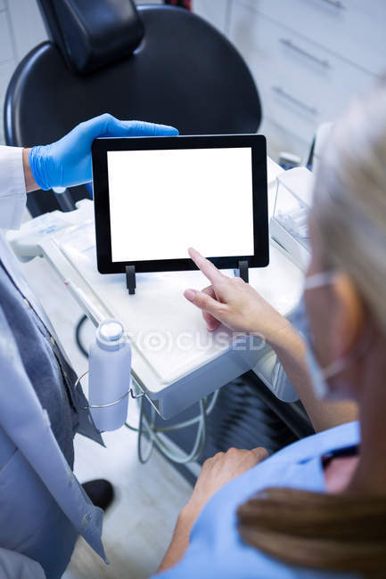 Immagine ritagliata di dentista e assistente dentale che lavora su tablet digitale presso la clinica dentistica — Foto stock