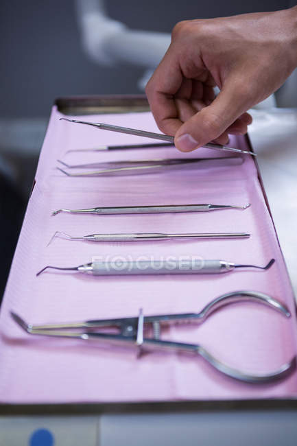 Geschnittenes Bild eines Zahnarztes, der Zahnwerkzeuge in der Klinik abholt — Stockfoto