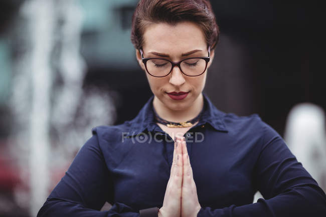 Primer plano de la mujer con las manos cerradas orando - foto de stock