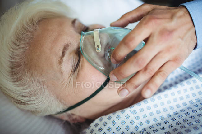 Лікар кладе кисневу маску на пацієнта в лікарню — стокове фото