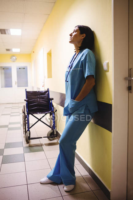 Infermiera depressa in piedi nel corridoio dell'ospedale — Foto stock