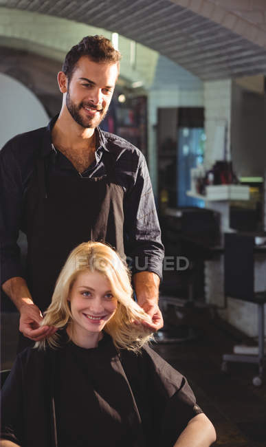 Красивий стиліст волосся з клієнтом в перукарні — стокове фото