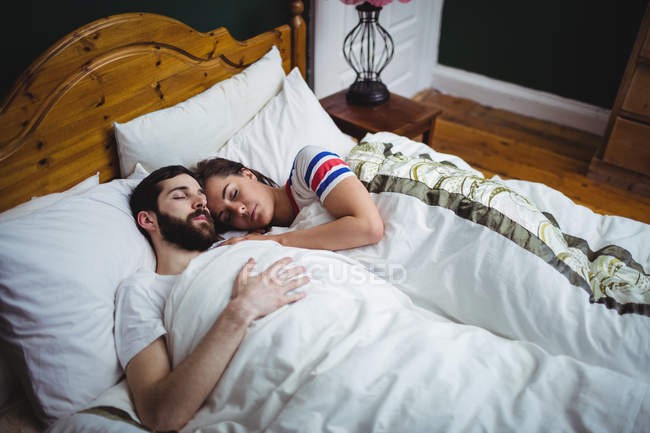 Couple sleeping together on bed at bedroom — Stock Photo
