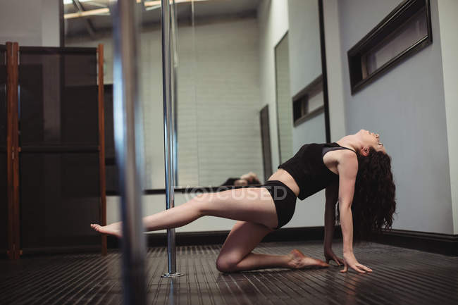 Танцовщица на шесте практикует танец в фитнес-студии — стоковое фото