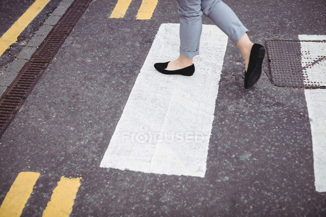 Low section of businesswoman walking on road — Stock Photo