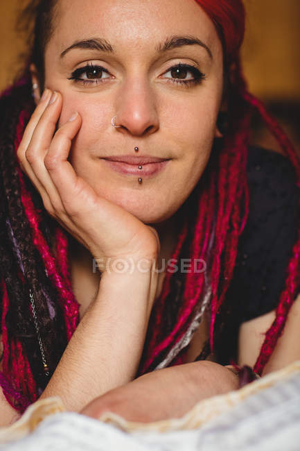 Close-up portrait of young woman relaxing on bed at home — Stock Photo