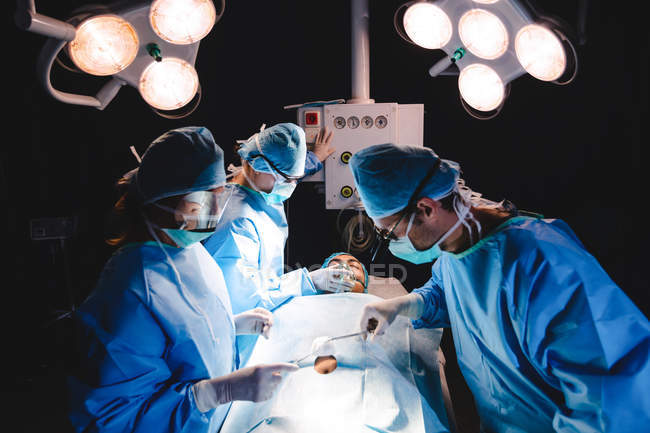 Хірурги, які виконують операцію в операційній кімнаті в лікарні — стокове фото