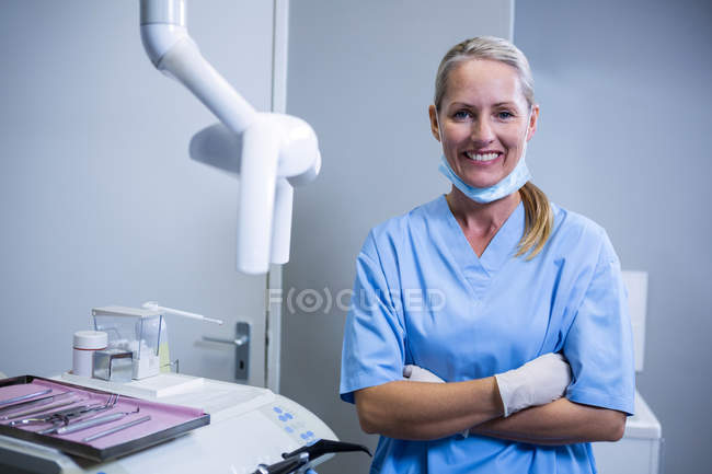 Asistente dental sonriendo a cámara en clínica dental - foto de stock