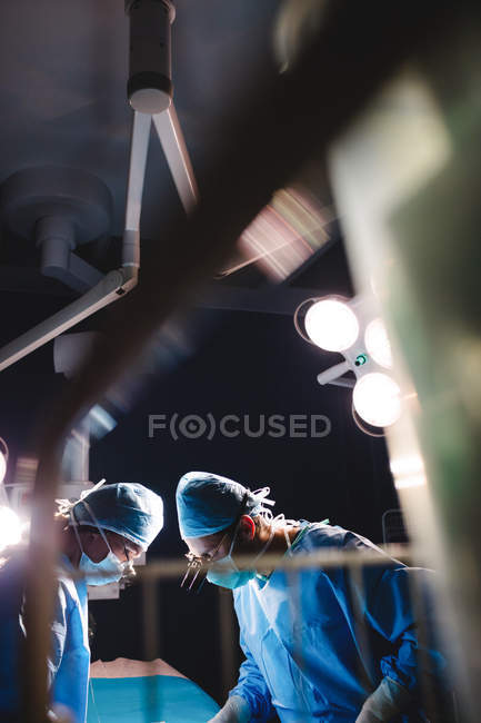 Cirurgiões que realizam operação na sala de operação do hospital — Fotografia de Stock