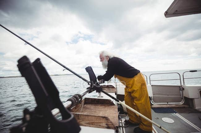 Вид сбоку с рыбацкой лодки на человека, глядящего в море — стоковое фото