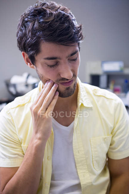 Unglücklicher Mann mit Zahnschmerzen in Klinik — Stockfoto
