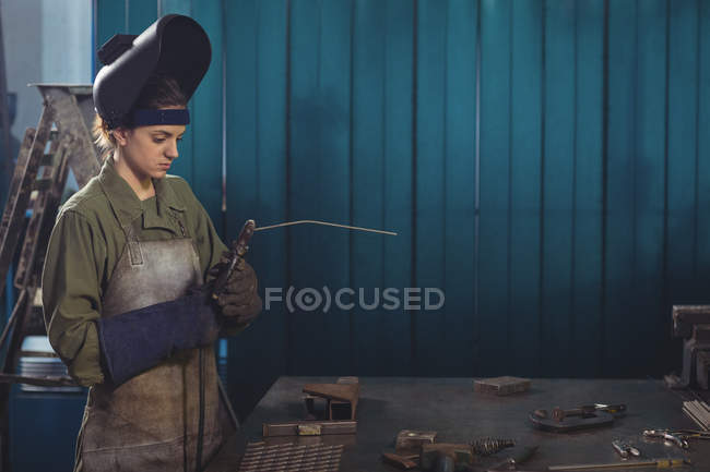 Soldador fêmea segurando arco de soldagem na oficina — Fotografia de Stock