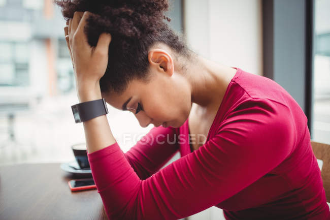 Upset woman sitting at table in restaurant — Stock Photo