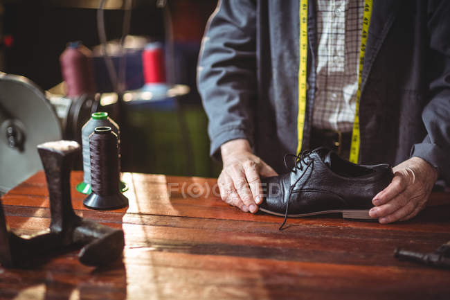 Mittelteil des Schusters bei der Untersuchung eines Schuhs in der Werkstatt — Stockfoto