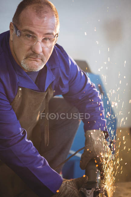 Soldador bonito corte de metal com ferramenta elétrica na oficina — Fotografia de Stock