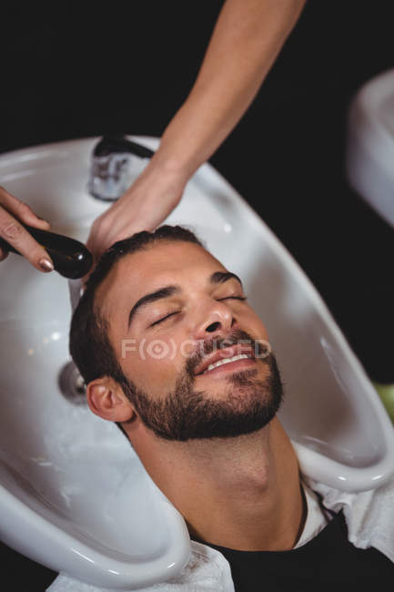 Мужчина моет волосы в салоне — стоковое фото