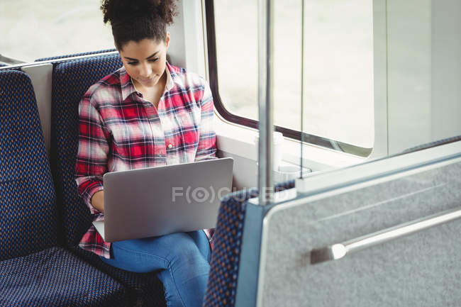 Woman with laptop while sitting in train — Stock Photo