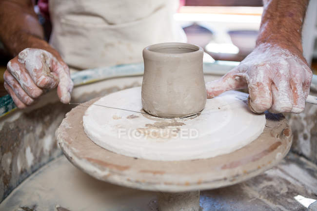 Mid section of potter making pot in pottery workshop — Stock Photo