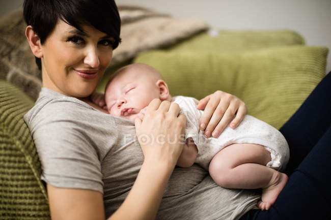 Close-up do bebê dormindo na mãe na sala de estar em casa — Fotografia de Stock