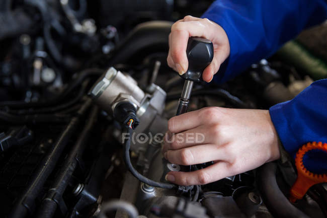Imagen recortada del motor mecánico de mantenimiento del coche en el garaje de reparación - foto de stock