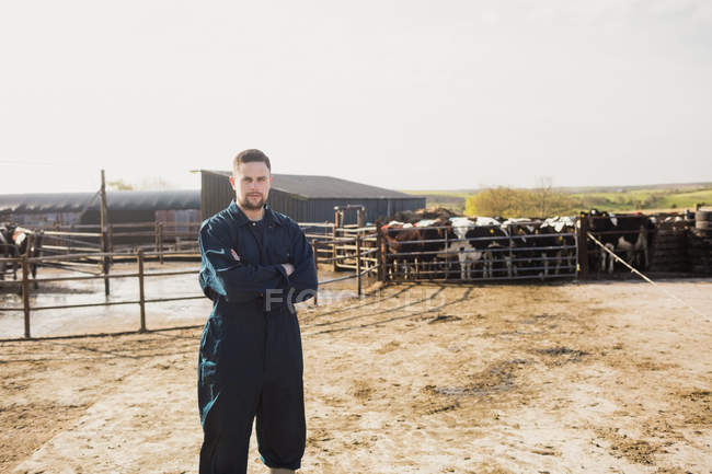 Porträt eines selbstbewussten Landarbeiters, der mit verschränkten Armen auf einem Feld steht — Stockfoto