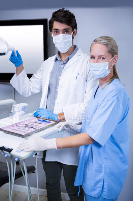 Dentista e assistente odontológico trabalhando juntos na clínica odontológica — Fotografia de Stock