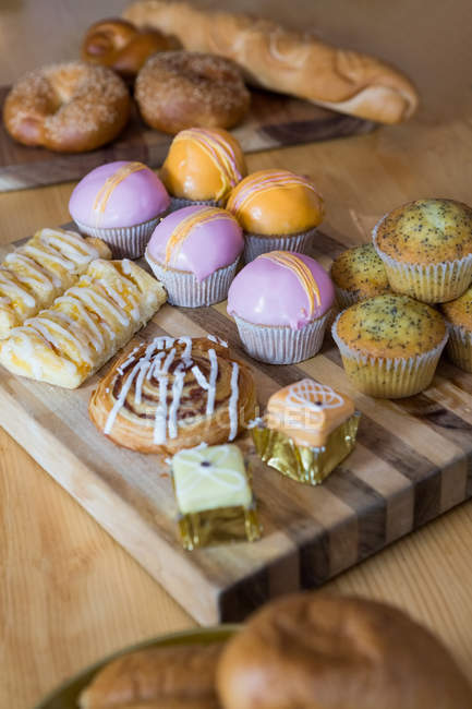 Nahaufnahme von Cupcakes auf Holztablett in Cafeteria — Stockfoto