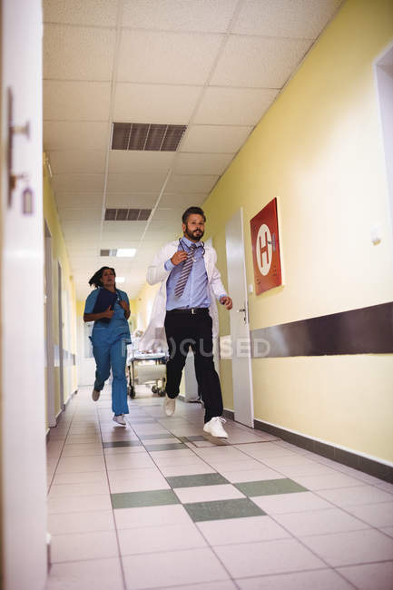 Doctor and nurse running in hospital corridor during emergency — Stock Photo