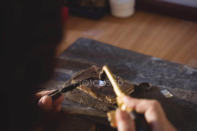Imagen recortada de Goldsmith anillo de fabricación por quemador en el taller - foto de stock