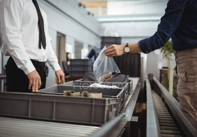 Passeggero mettere sacchetto di plastica in vassoio per il controllo di sicurezza in aeroporto — Foto stock