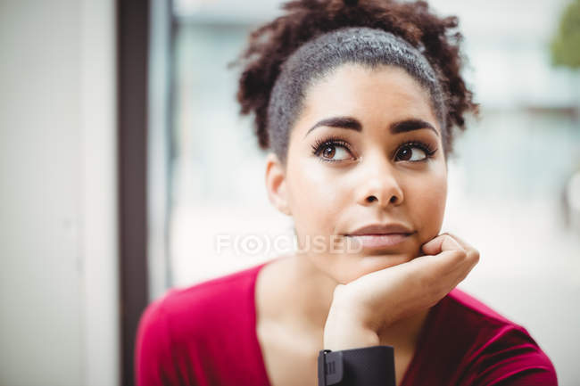 Nahaufnahme einer nachdenklichen jungen Frau mit der Hand am Kinn im Restaurant — Stockfoto