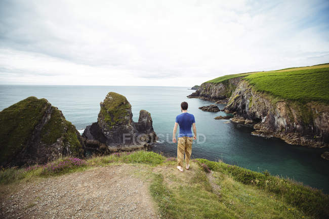 Vista posteriore dell'uomo in piedi sulla scogliera — Foto stock