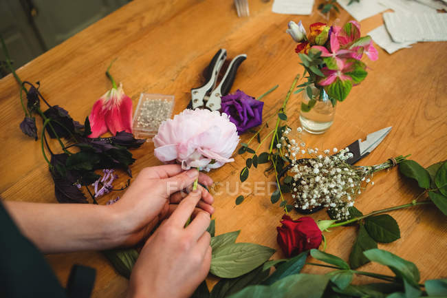 Обрізане зображення жіночого флориста, який готує квітковий букет у своєму квітковому магазині — стокове фото