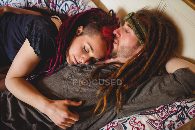 Високий кут зору молодої пари хіпстерів, що розслабляється на ліжку вдома — стокове фото