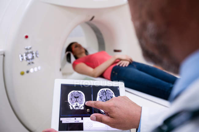 Arzt schaut sich Gehirn-Mami-Scan auf digitalem Tablet im Krankenhaus an — Stockfoto