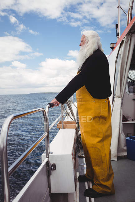 Pescador olhando para o mar de barco de pesca — Fotografia de Stock