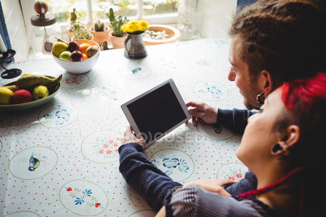 Image recadrée d'un couple utilisant une tablette à la maison — Photo de stock