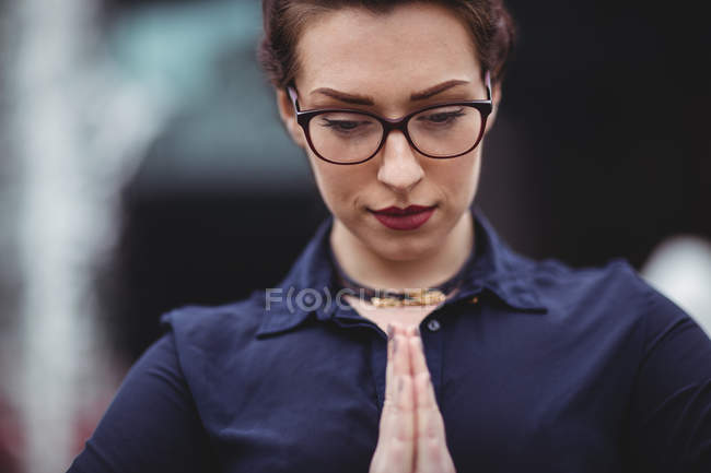 Primer plano de la mujer de negocios con las manos cerradas rezando - foto de stock